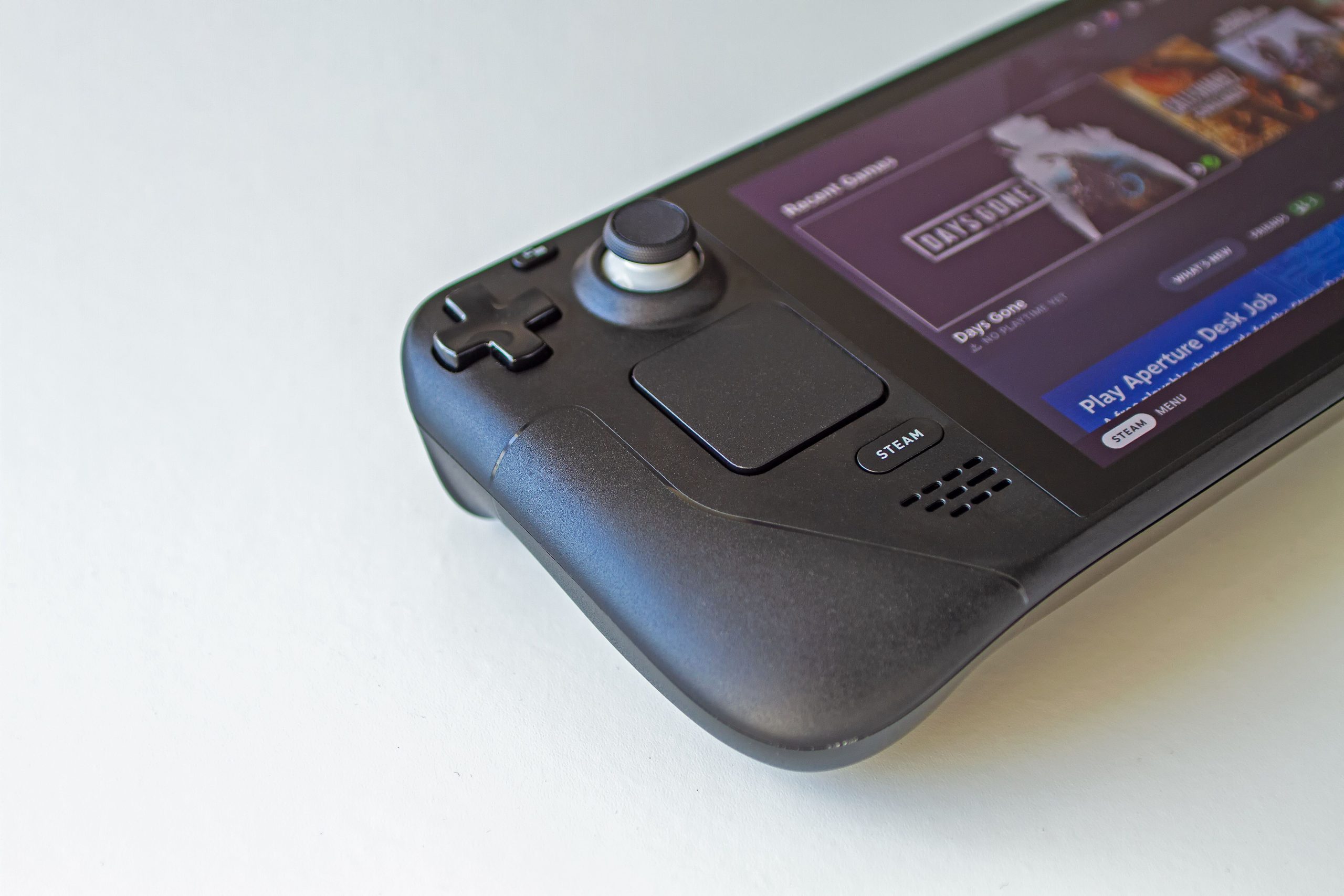 Close-up of the lower left side of a Steam Deck showing the D-pad, thumbstick, trackpad and Steam button